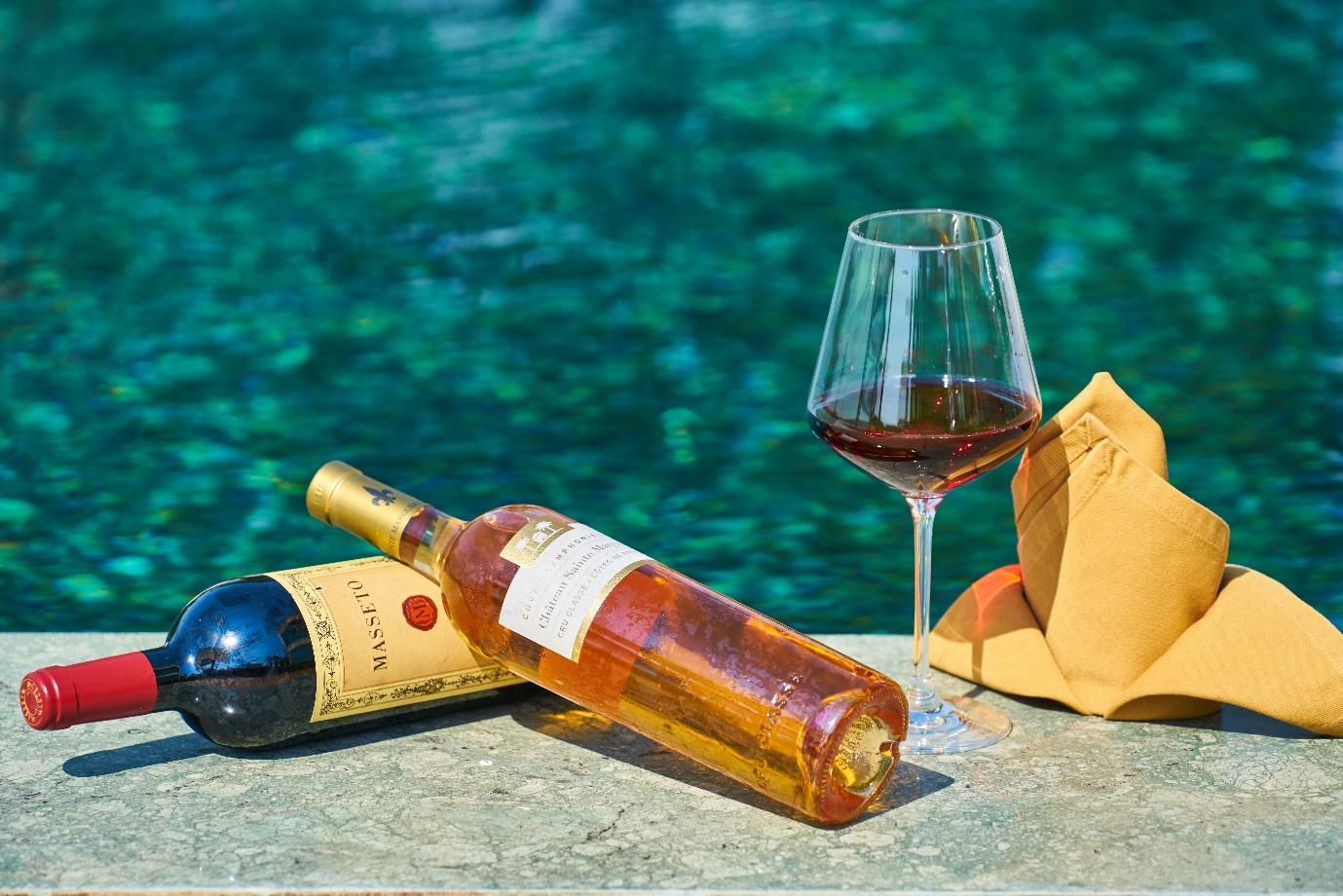 Wine bottles near a pool